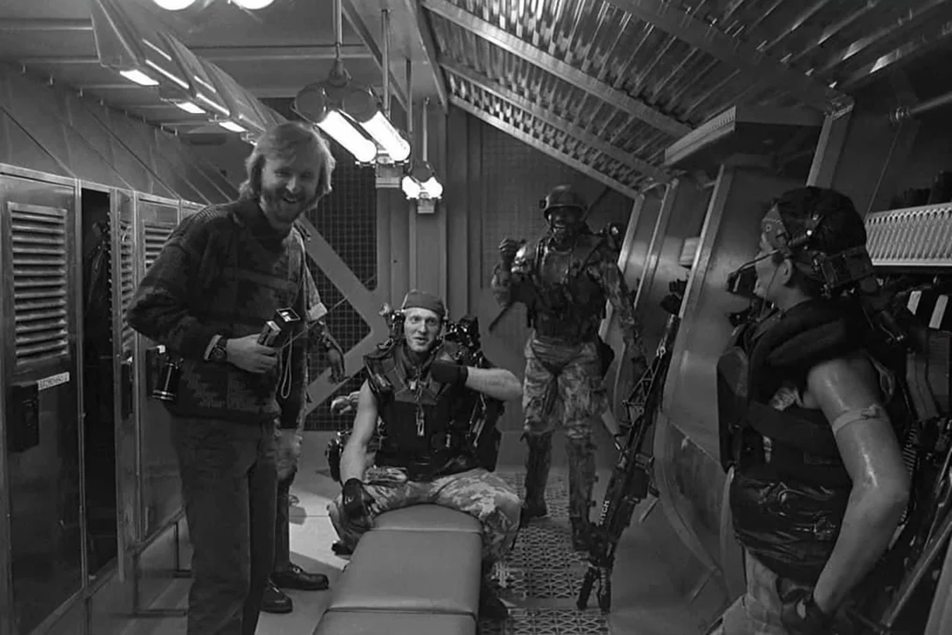 Al Matthews as Apone laughing on the Aliens Sulaco locker set with James Cameron, William Hope, and Jenette Goldstein