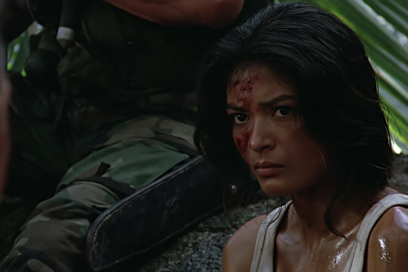 Anna Gonsalves crouching beside the commandos at their defensive position in the dark jungle
