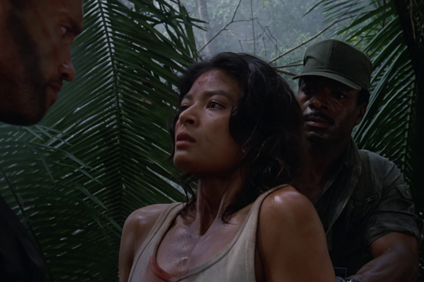 Anna Gonsalves held between two commandos in the jungle, her tank top stained with blood
