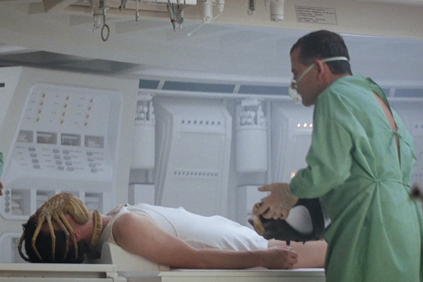 Ash and Dallas over Kane with a Facehugger still locked to his face