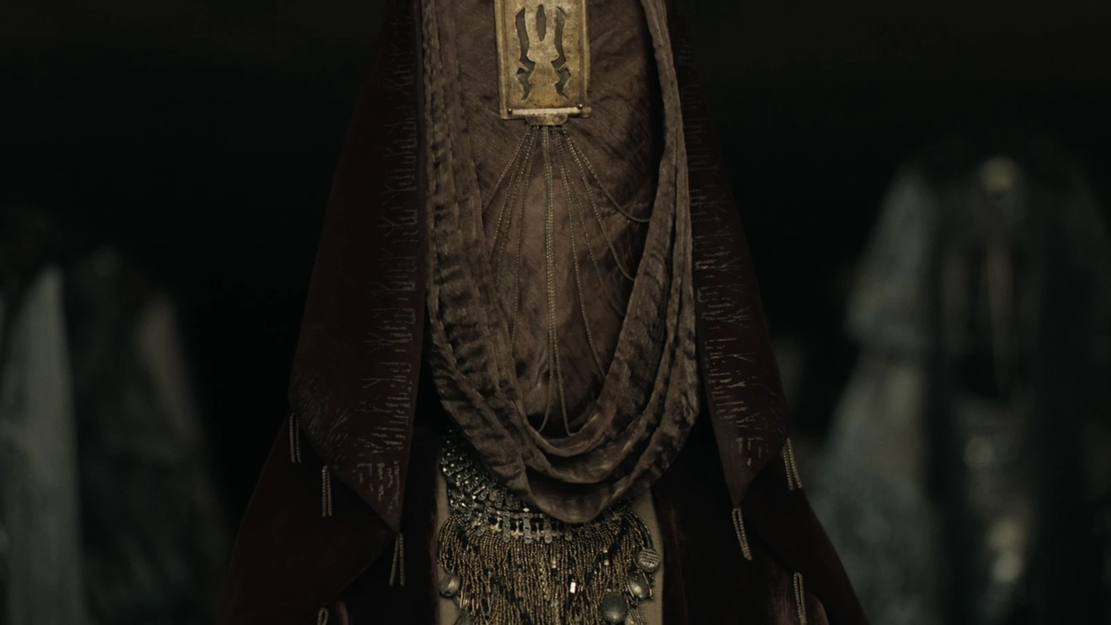 A veiled Bene Gesserit sister in ceremonial robes and ornate jewelry