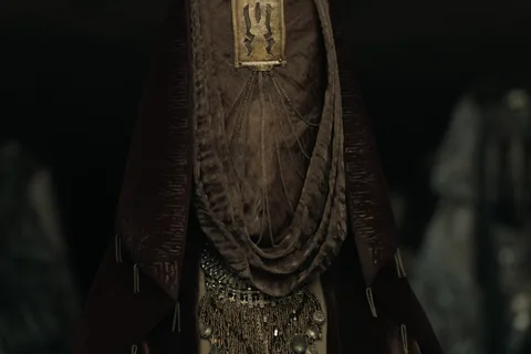 A veiled Bene Gesserit sister in ceremonial robes and ornate jewelry