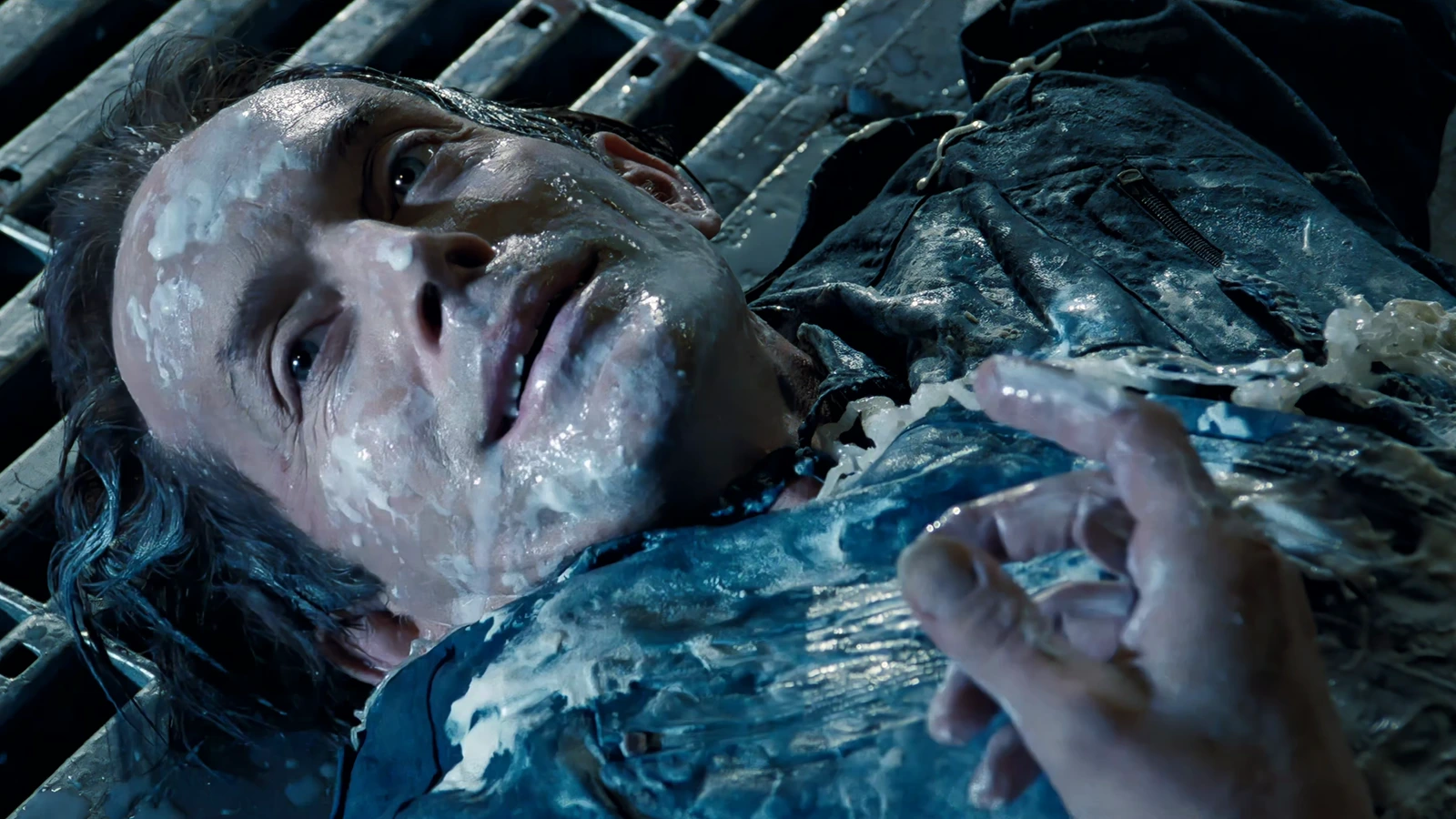 Damaged Bishop android lying on a metal grate with white synthetic blood on Fury 161