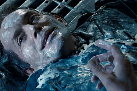 Damaged Bishop android lying on a metal grate with white synthetic blood on Fury 161