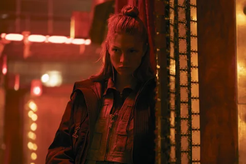Hunter Schafer as Cora in red light in Blade Runner 2099
