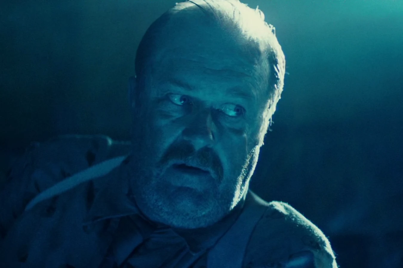 Close-up of Captain Harry Bryant in blue light during the replicant briefing in Blade Runner