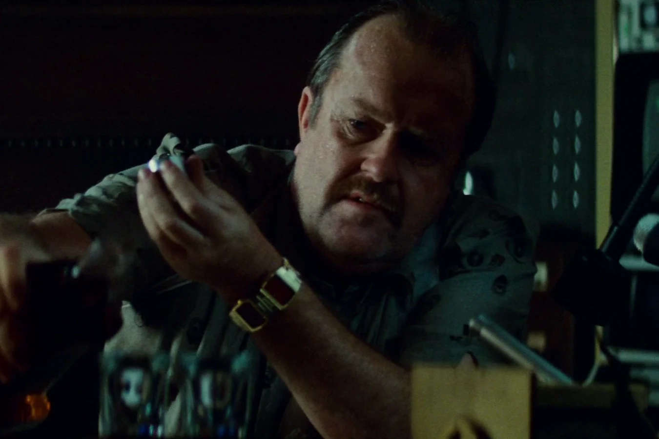 Captain Harry Bryant pouring whiskey at his desk in the LAPD office in Blade Runner