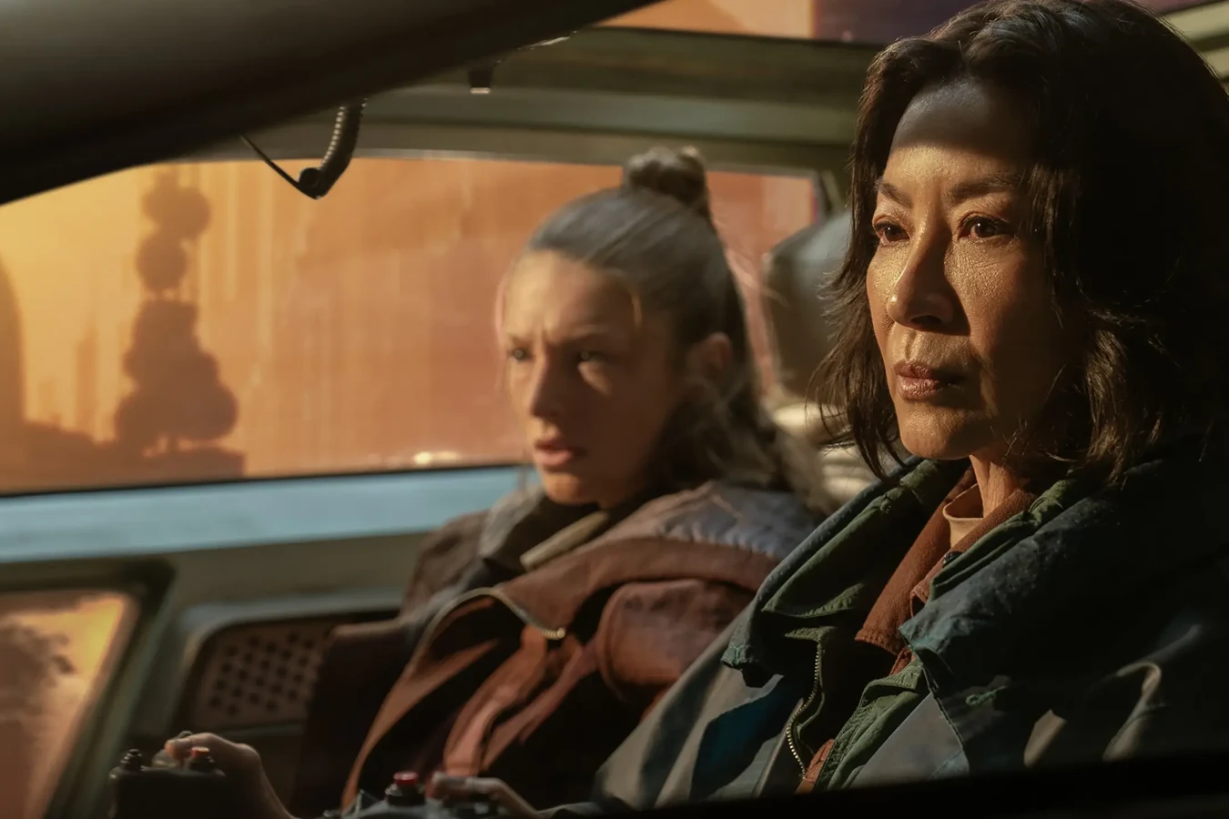 Michelle Yeoh as Olwen in the front seat of a spinner, with Hunter Schafer as Cora behind her, in Blade Runner 2099