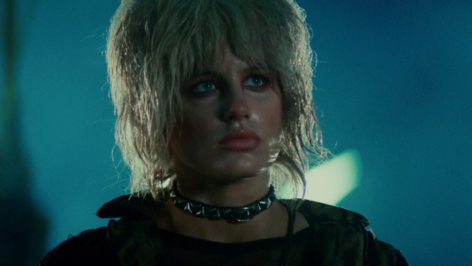 Daryl Hannah as Pris with wet hair and a spiked choker on a rainy street in Blade Runner