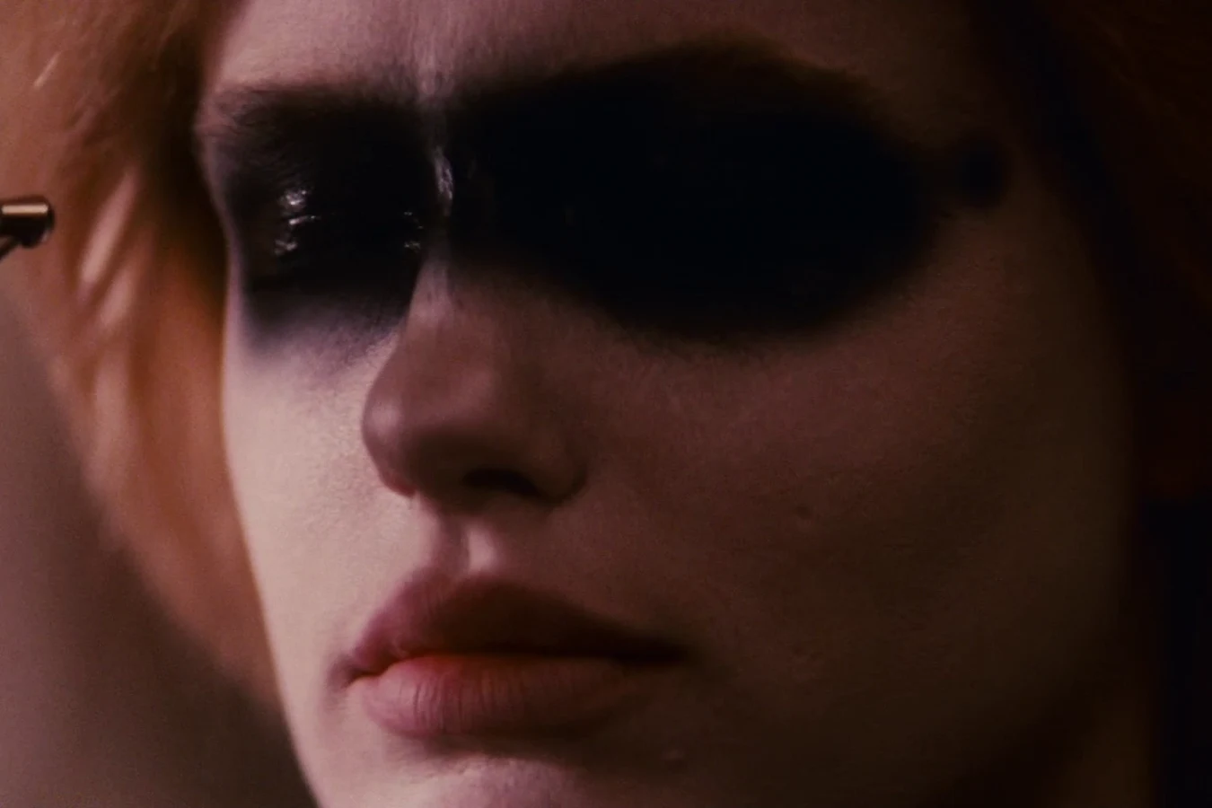 Pris airbrushing a black band of makeup across her eyes in Sebastian's apartment in Blade Runner
