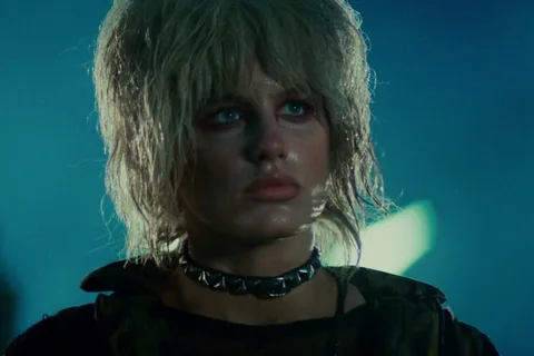 Daryl Hannah as Pris with wet hair and a spiked choker on a rainy street in Blade Runner