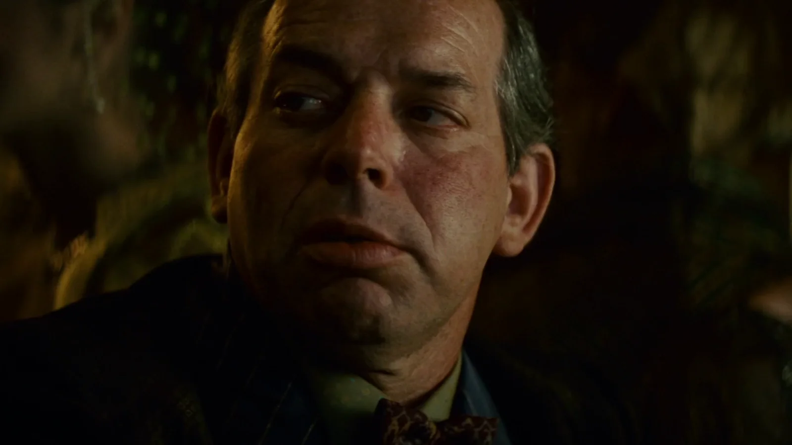 Hy Pyke as Taffey Lewis in a bow tie glancing sideways at his bar in the Snake Pit in Blade Runner