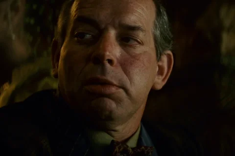 Hy Pyke as Taffey Lewis in a bow tie glancing sideways at his bar in the Snake Pit in Blade Runner
