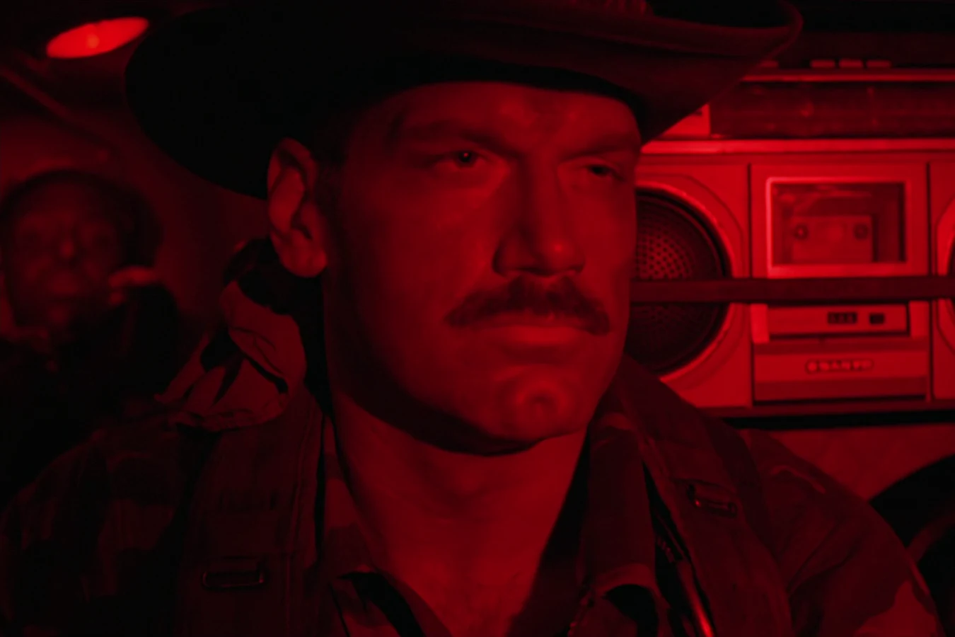 Blain Cooper lit by the red cabin light of the helicopter flying the team into Val Verde in Predator