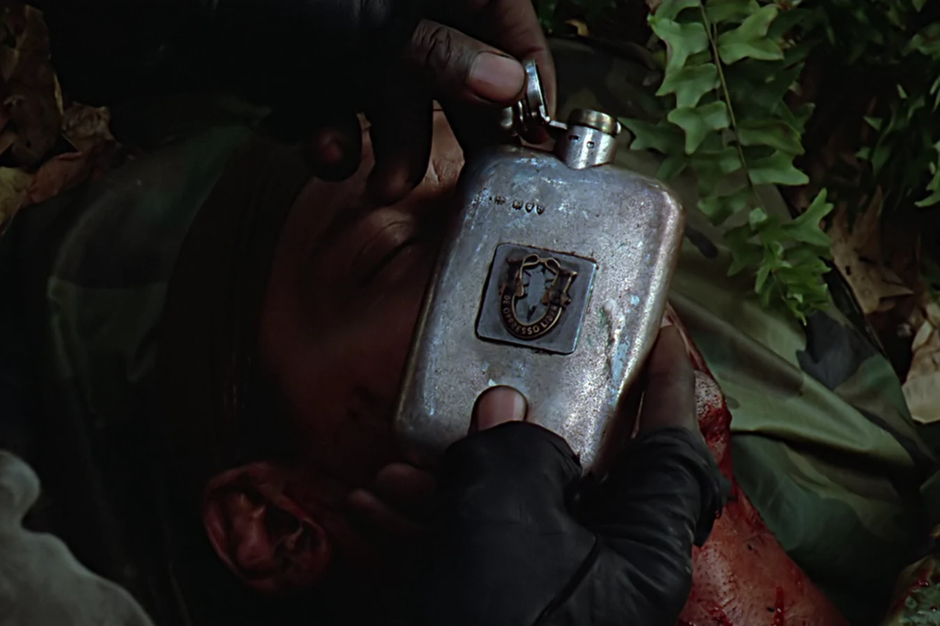 Mac holding Blain Cooper's flask over his body in Predator