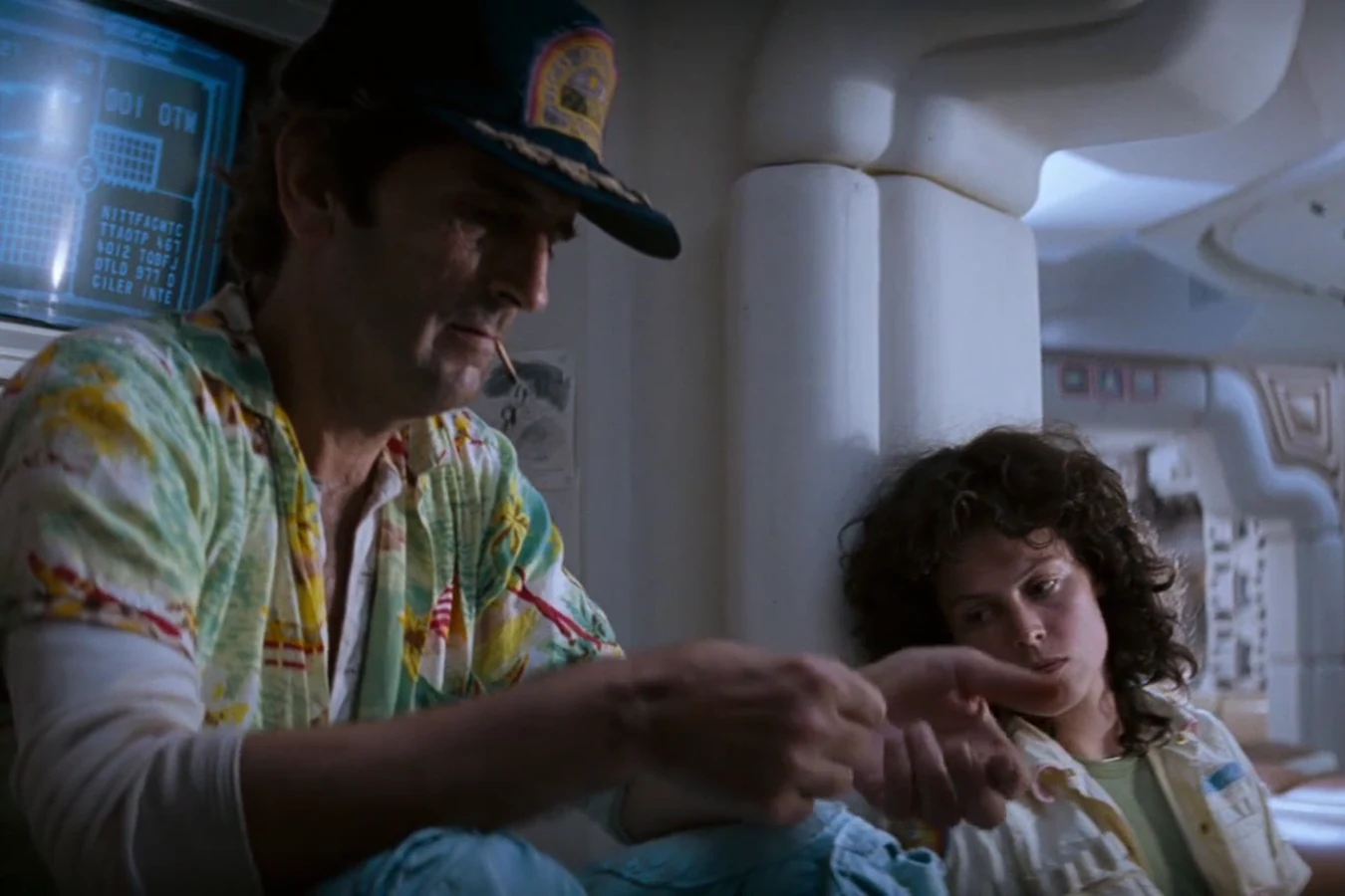 Brett points at a display while Lambert watches on the Nostromo in Alien