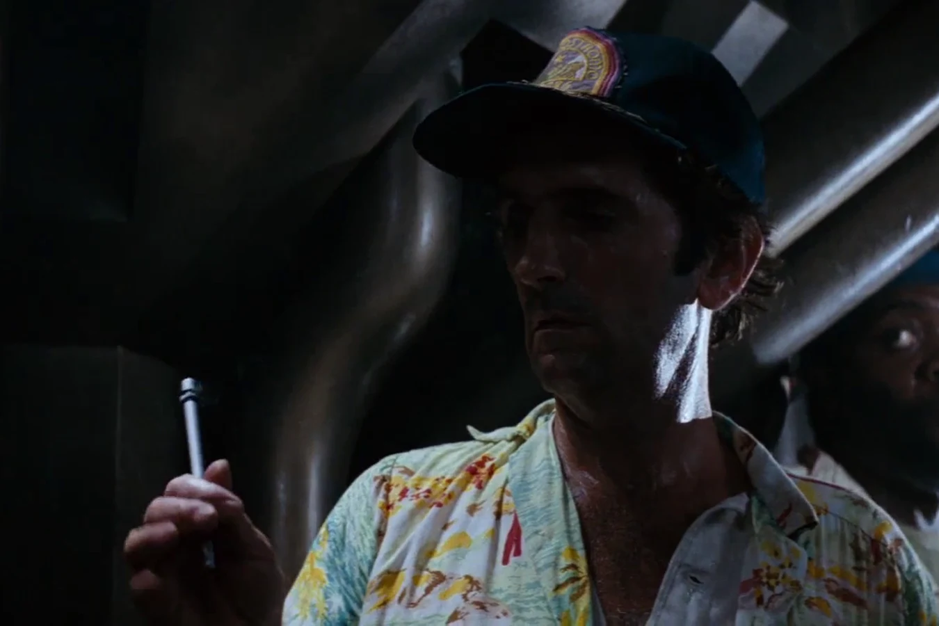 Brett looks at his pen after the acid ate it, with Parker behind him, on the Nostromo