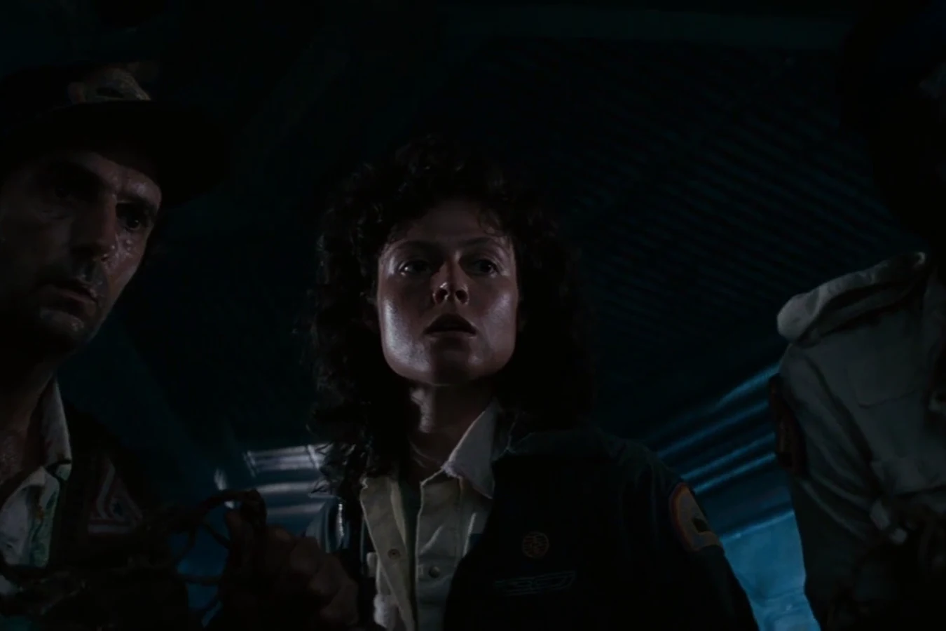 Brett, Ripley, and Parker in a dark Nostromo compartment during the search in Alien