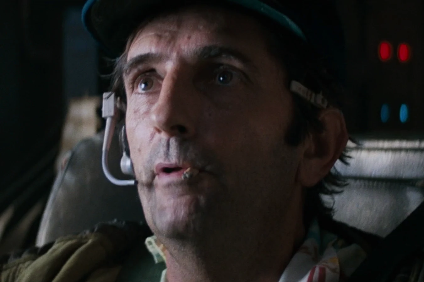 Brett smokes a cigarette in his cap and headset on the Nostromo in Alien