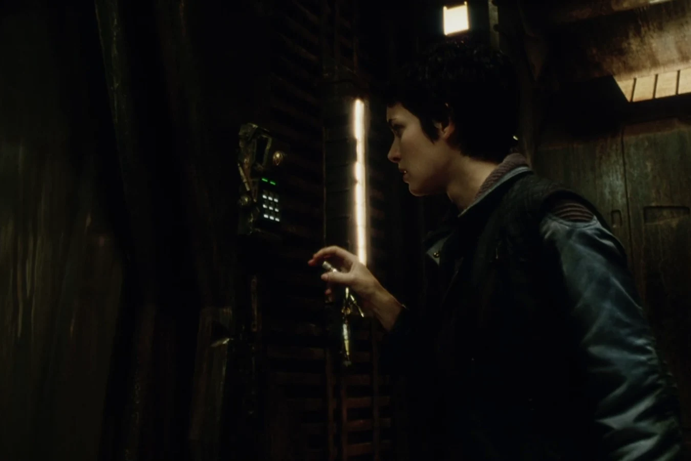 Call reaching for a door panel in a dark Auriga corridor