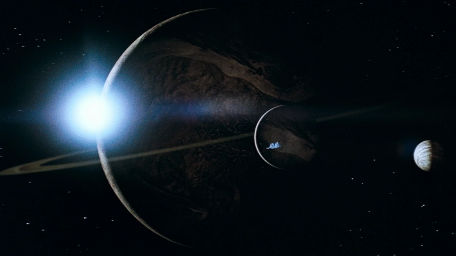 The ringed gas giant in Alien, with the Nostromo crossing a moon and LV-223 off to the side