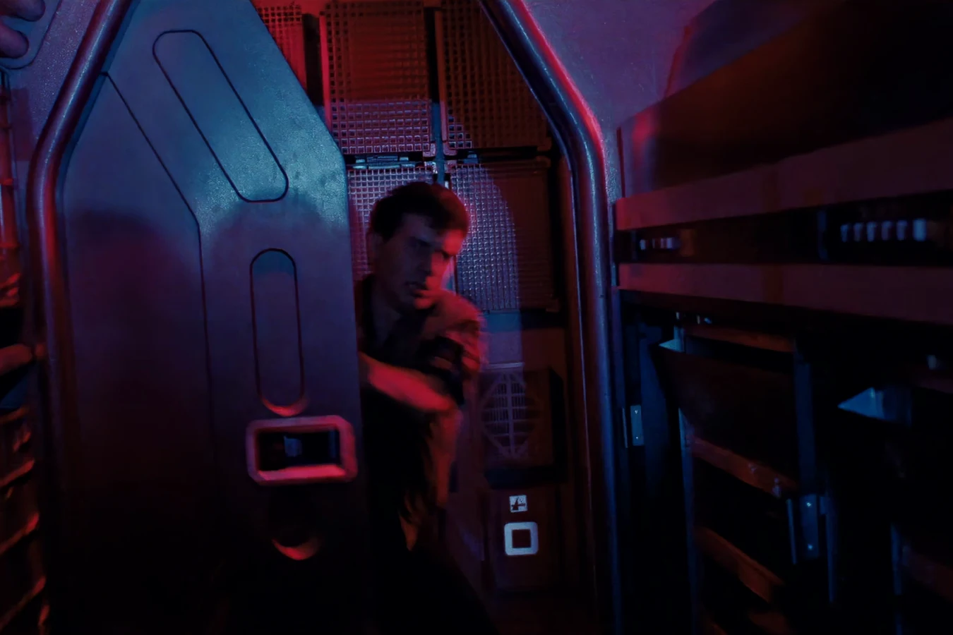 Carter Burke at the Operations door under red light during the Warrior attack in Aliens