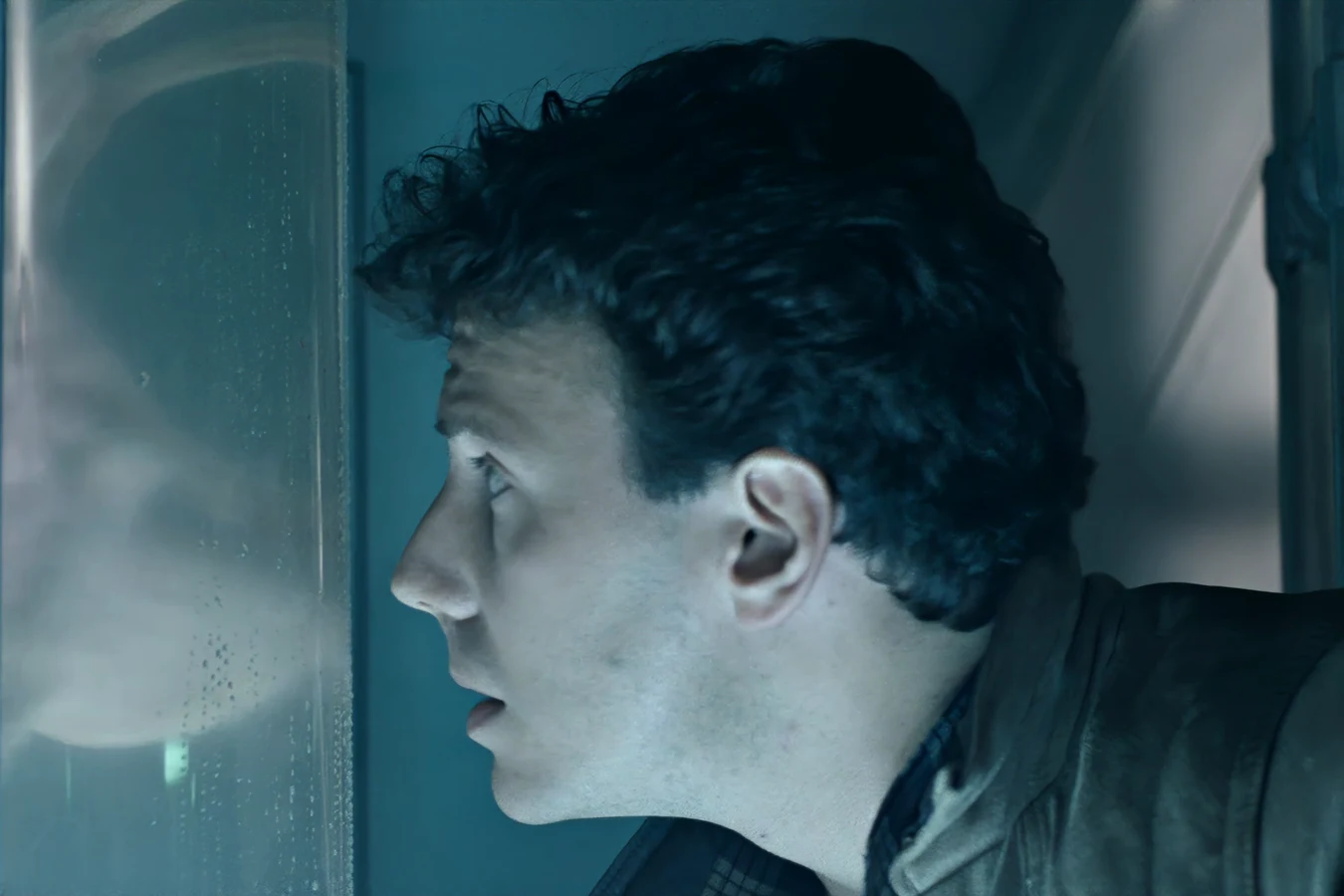 Carter Burke looking through the medlab glass at a Facehugger in stasis in Aliens