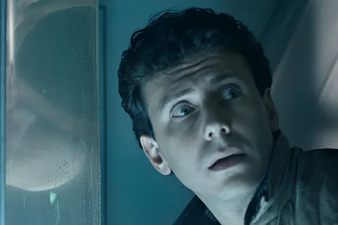 Carter Burke staring through the medlab glass at a Facehugger in Aliens