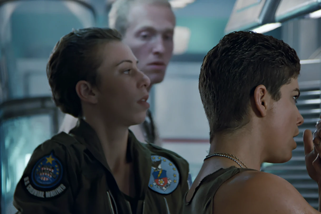 Colette Ferro in a Colonial Marine flight suit in the Sulaco locker line, with Vasquez in the foreground in Aliens