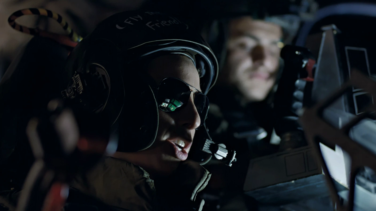 Corporal Colette Ferro in a flight helmet and sunglasses at the Bug Stomper controls in Aliens, with Spunkmeyer behind her