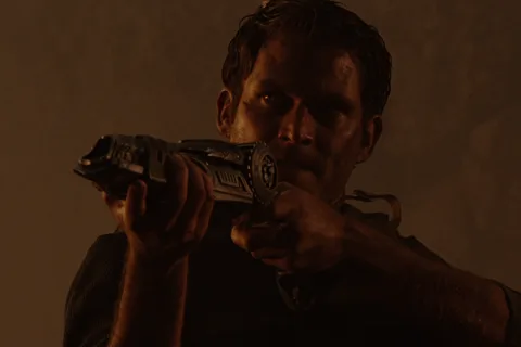 Dallas Howard aims Wolf's plasma pistol during the Gunnison outbreak in Aliens vs. Predator: Requiem