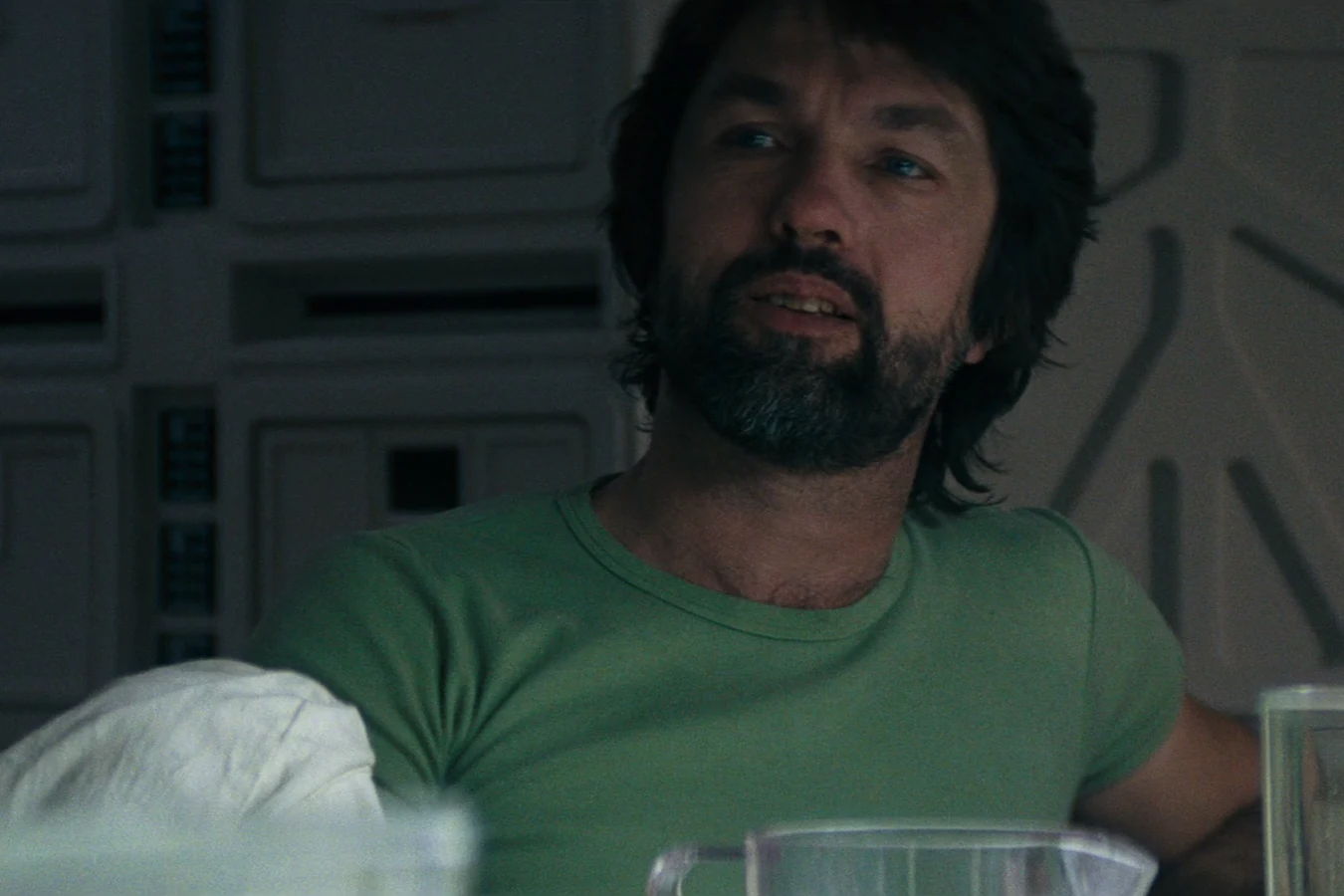 Dallas in a green shirt at the Nostromo mess table in Alien