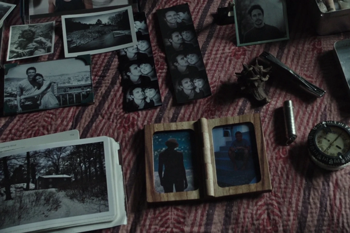 Photographs, a wooden double frame, and cabin tools laid out from Daniels and Jacob's private stores