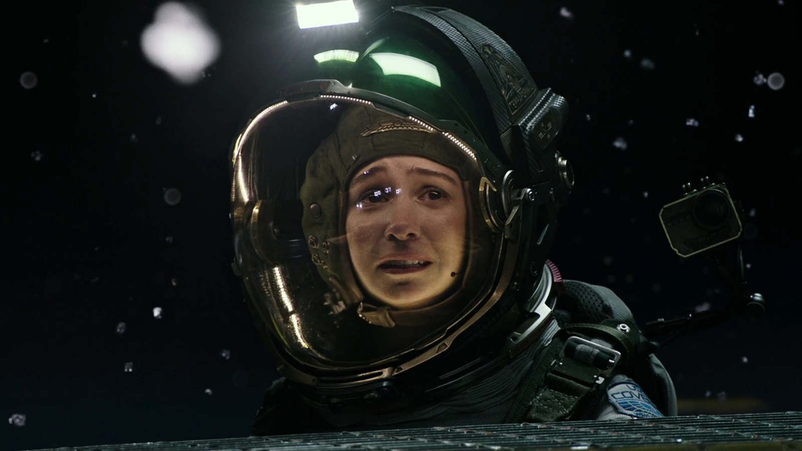 Daniels in an EVA helmet on the cargo lift outside the Covenant, debris floating past the visor