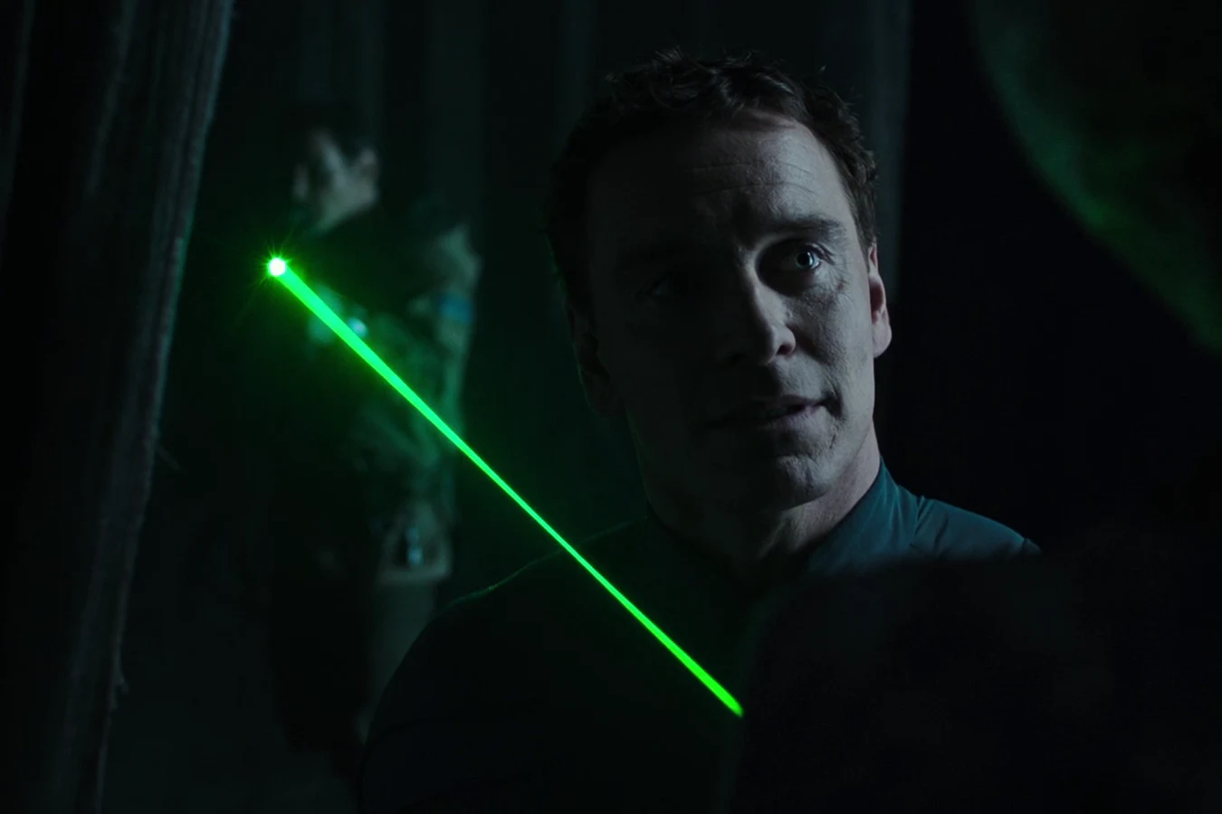 David facing the Neomorph as the green laser sight of Oram's rifle cuts across the temple