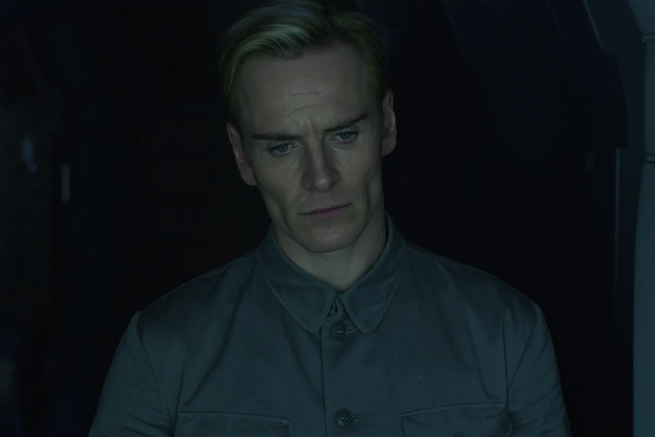 David in a grey shirt standing in a dark corridor of the Prometheus
