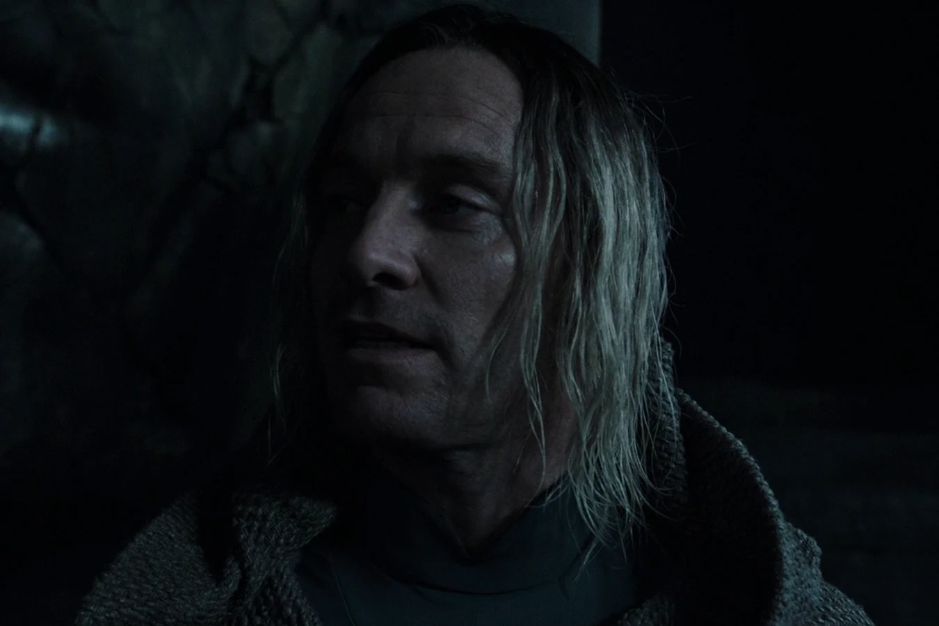 David with long hair and a hooded cloak in the dark of the dead city on Planet 4