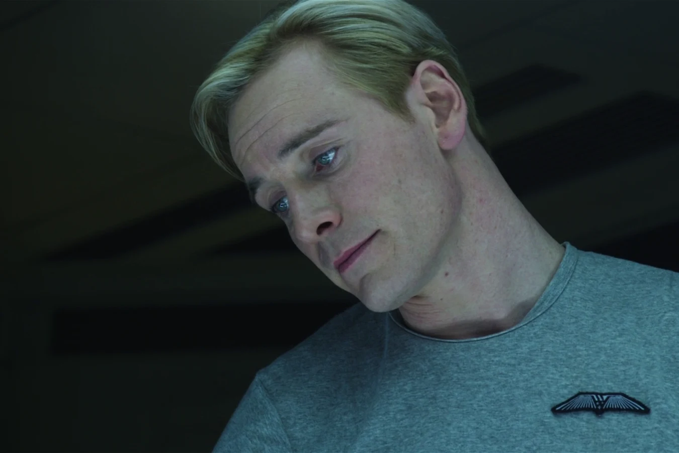 David tilting his head in a grey shirt aboard the Prometheus