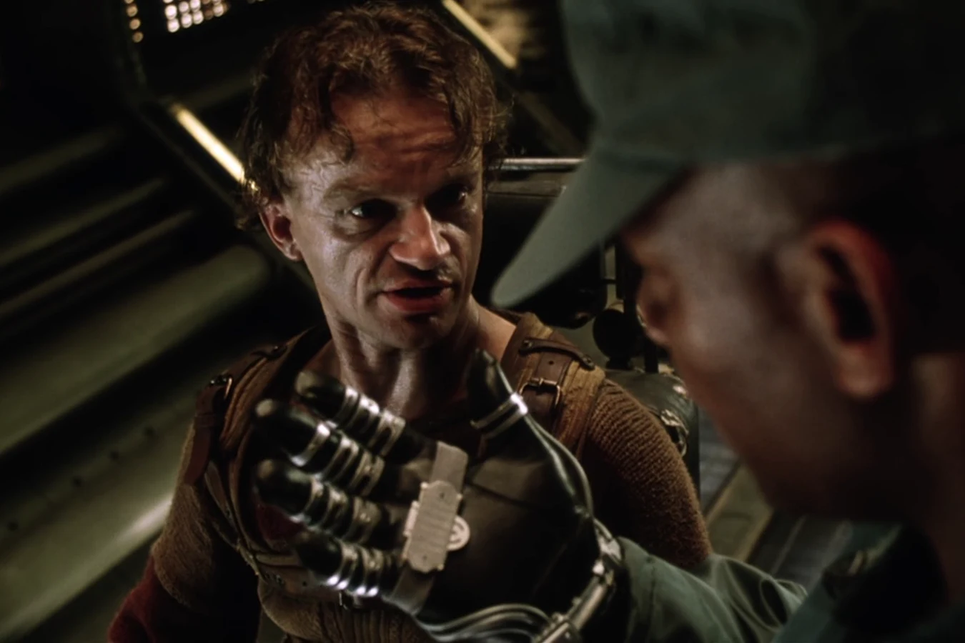 Vriess in his wheelchair facing a USM soldier at the Auriga airlock