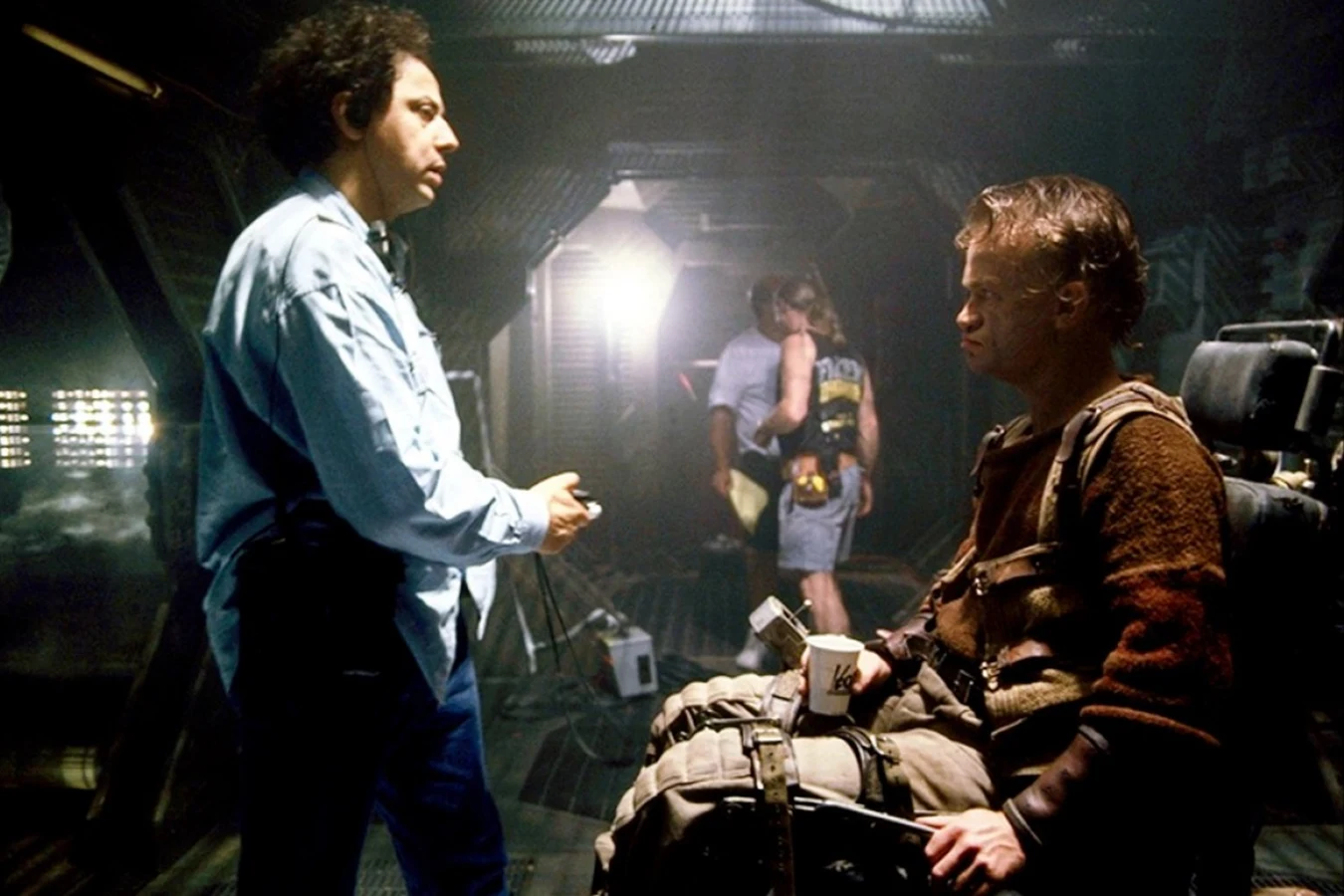 Jean-Pierre Jeunet directing Dominique Pinon, seated in Vriess's wheelchair with a coffee cup, on the set of Alien: Resurrection