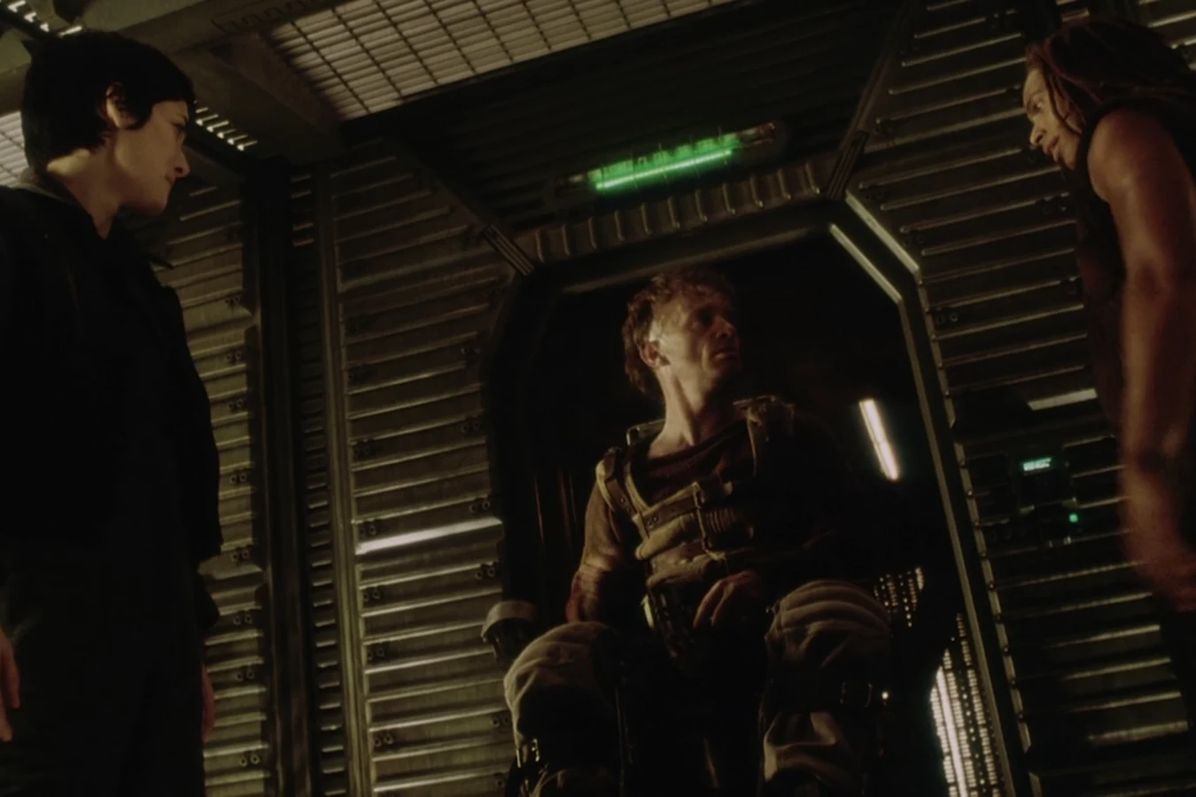 Vriess sitting in a freight elevator with his shotgun raised as the survivors find him