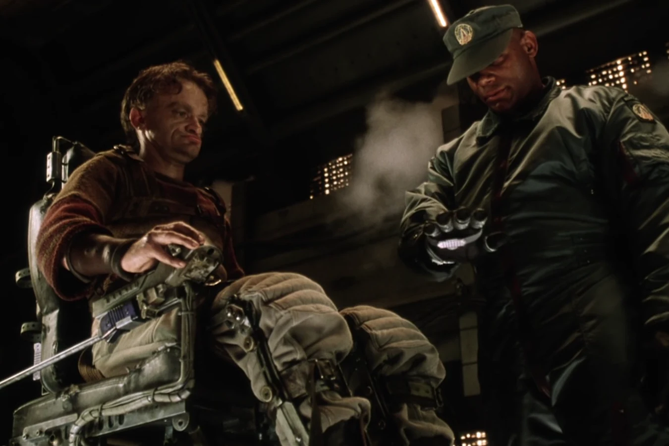 Vriess in his wheelchair beside a USM soldier during the weapons search