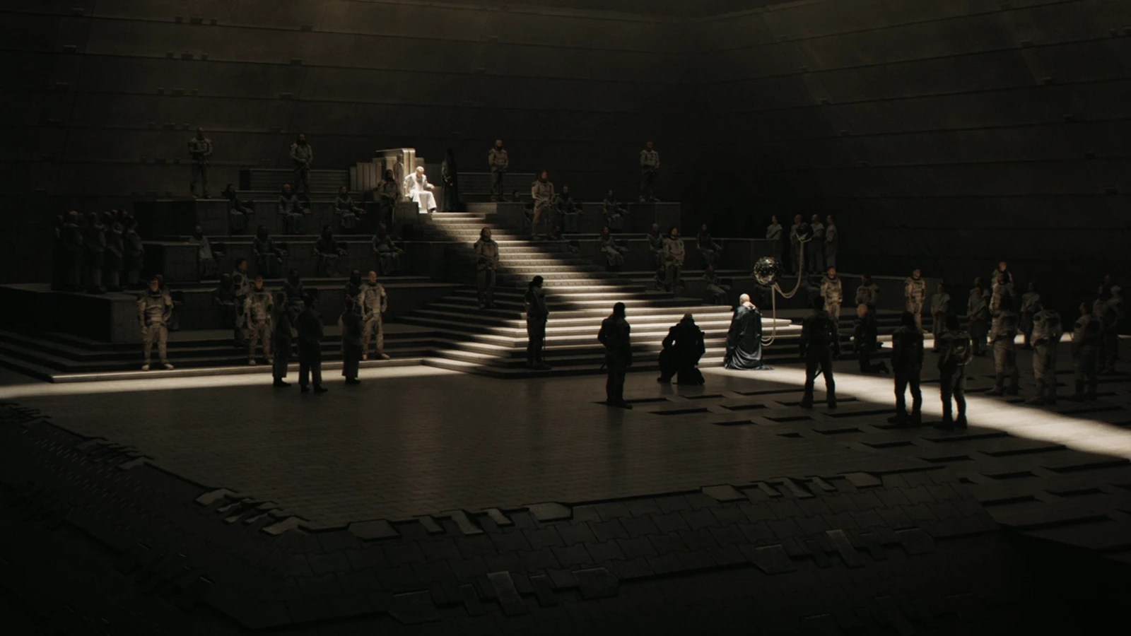A formal audience in a vast Imperial hall with a kneeling figure before a throne