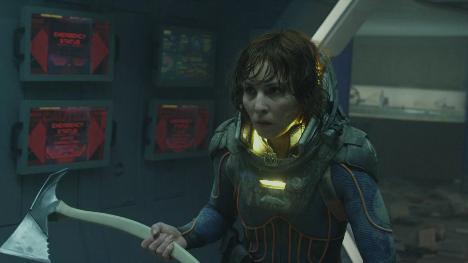 Elizabeth Shaw in a damaged spacesuit on the lifeboat, holding a fire axe under red emergency screens