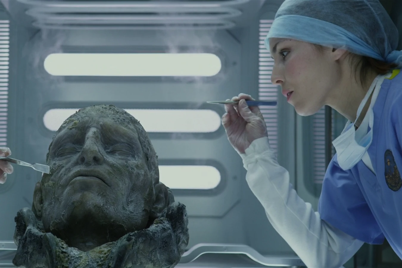 Elizabeth Shaw in a lab beside the preserved head of an Engineer