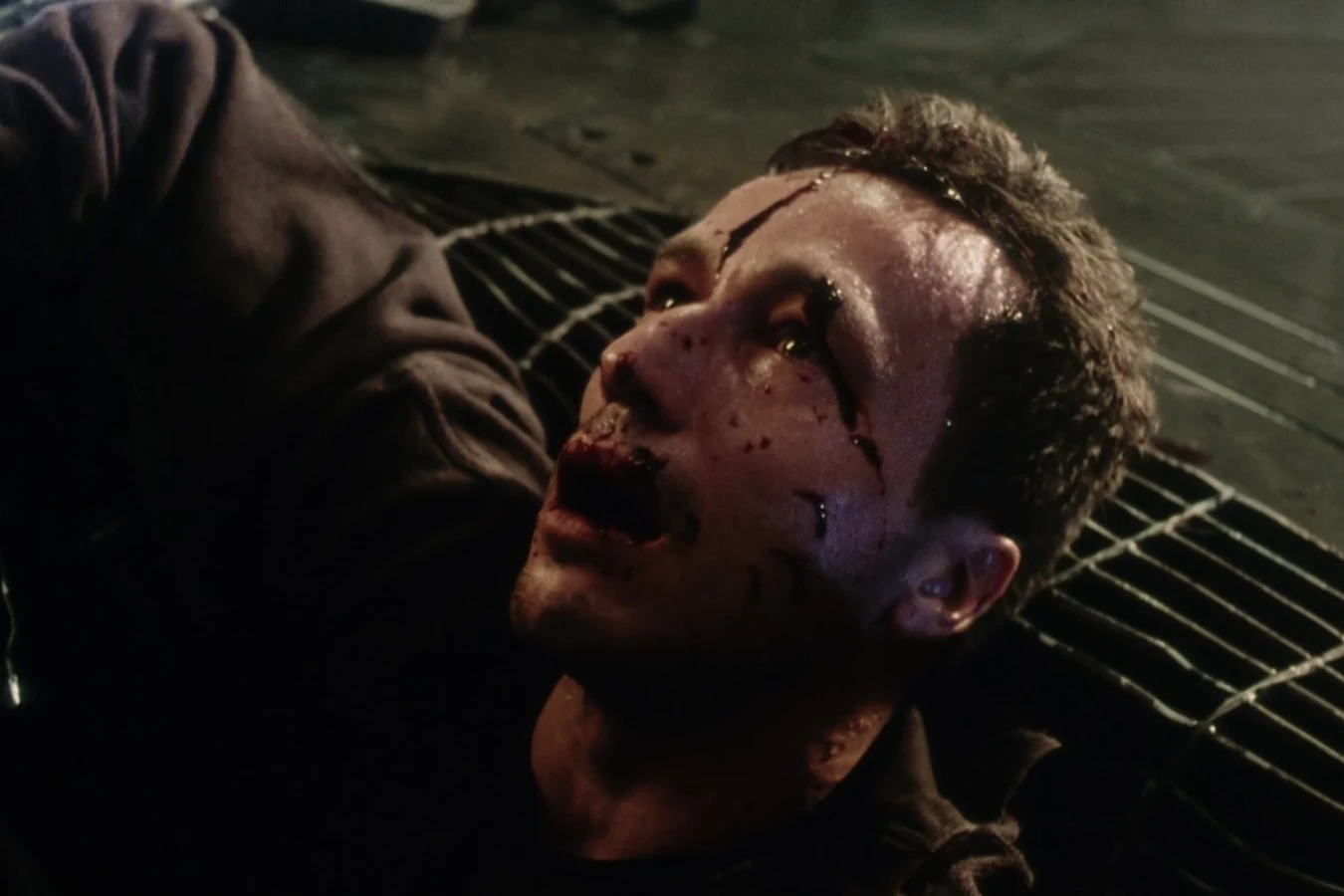 Elgyn lying dead and bloodied on the floor grate after the Xenomorph attack