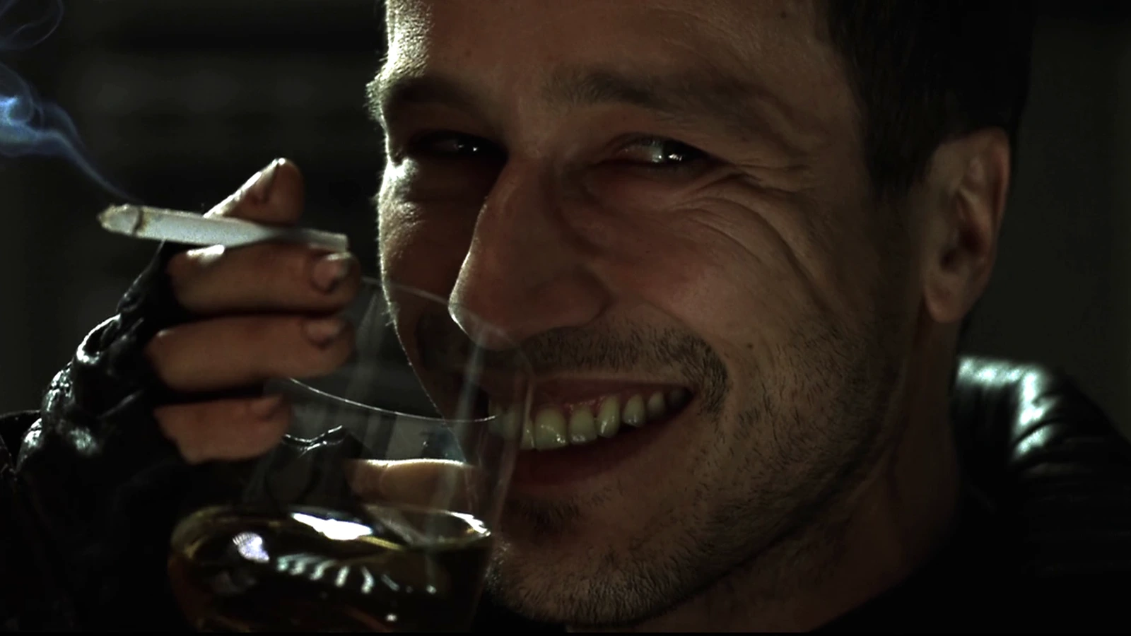 Elgyn grinning over a drink and a cigarette in Alien: Resurrection