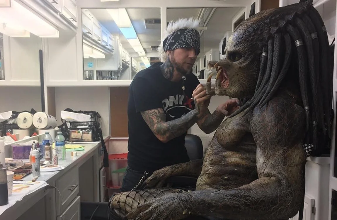 A Behind The Scenes photo of the Fugitive Predator costume being put on