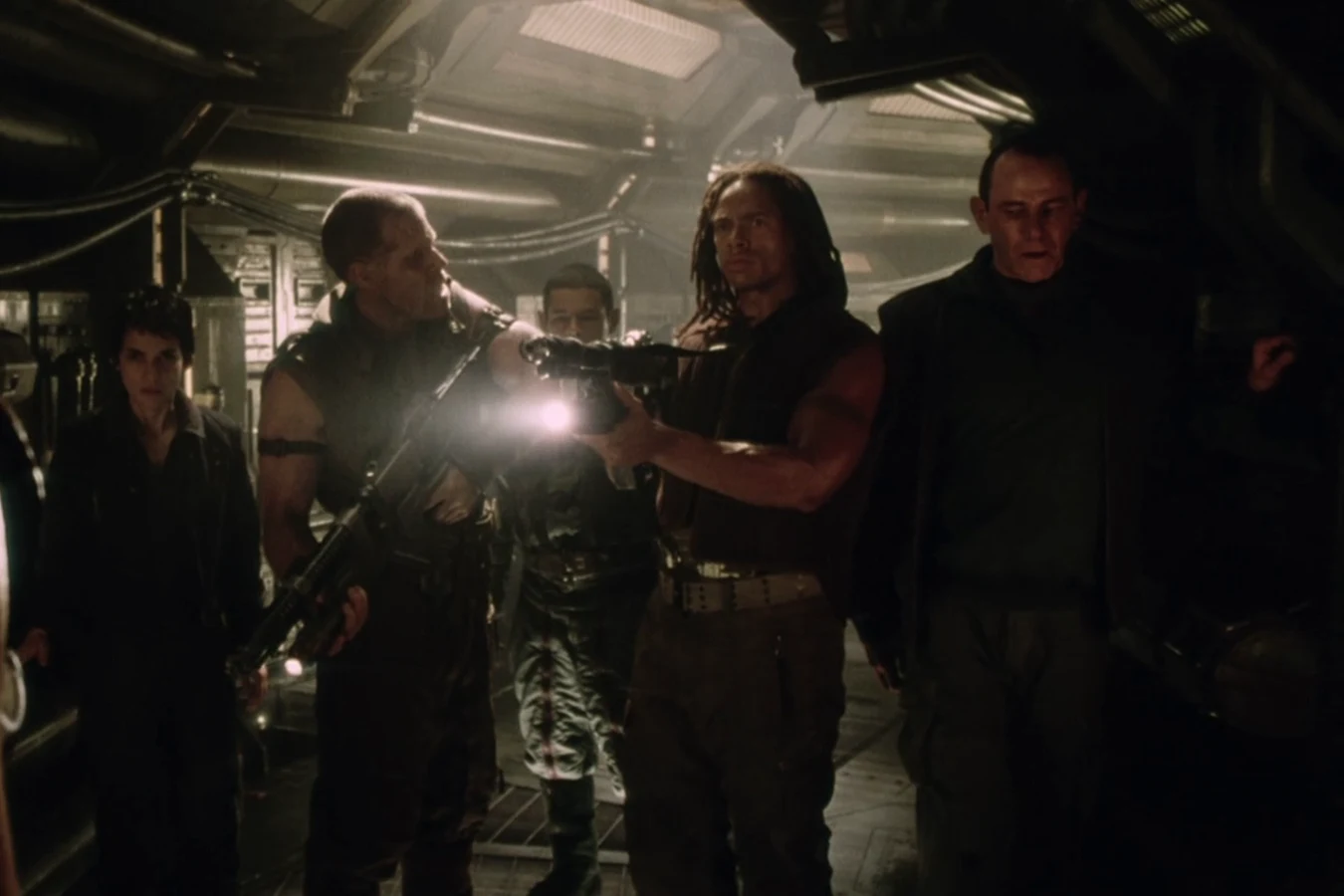 Christie aiming a light-mounted gun down an Auriga corridor beside Johner, Call, Distephano, and Wren