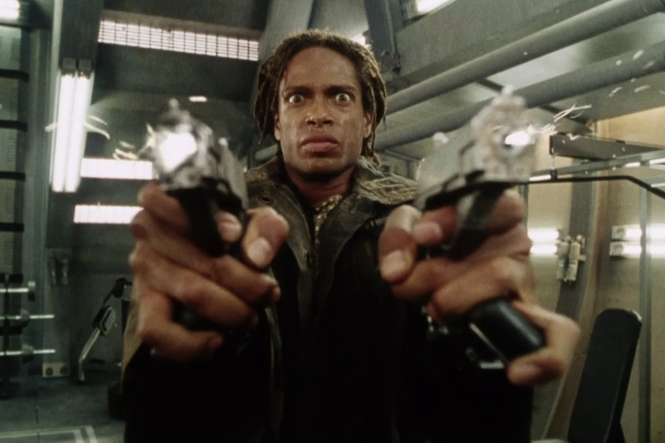 Christie aiming both of his wrist-mounted pistols in the Auriga mess hall